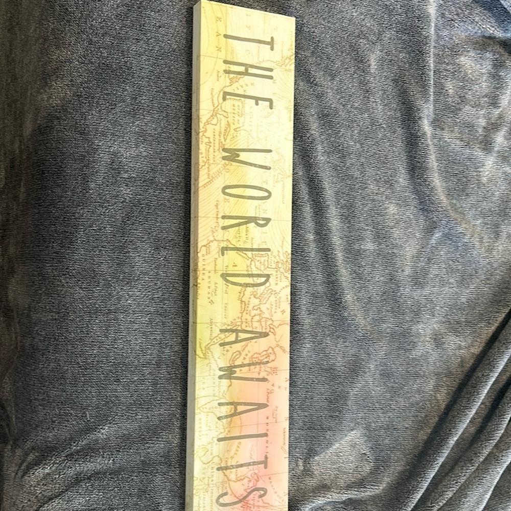 Sign for a bedroom “The world Awaits”
